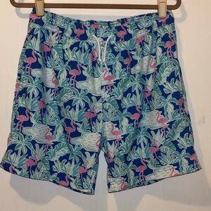 Men's Resort Swim Trunks with a pink flamingo and blue leaves pattern.